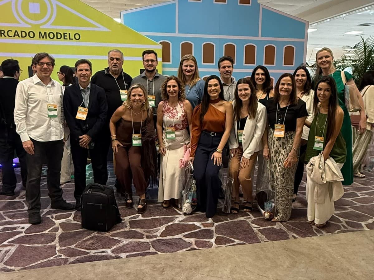 Grupo de médicos da SCR reunidos em um congresso, sorrindo para a foto.
